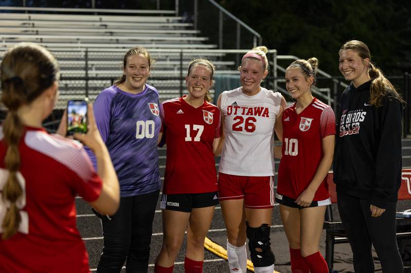 Emerson Hutchinson (2) of Metamora takes photo of teammates (left to right) Kristen Hoenert (00), Callie Sturgell (17), Taylor Brandt (26 of Ottawa), Emerson Graf (10) and Emily Points after awarding Brandt with “Player Of The Game” on Tuesday, May 21, 2025 at Malone Field in Metamora.
