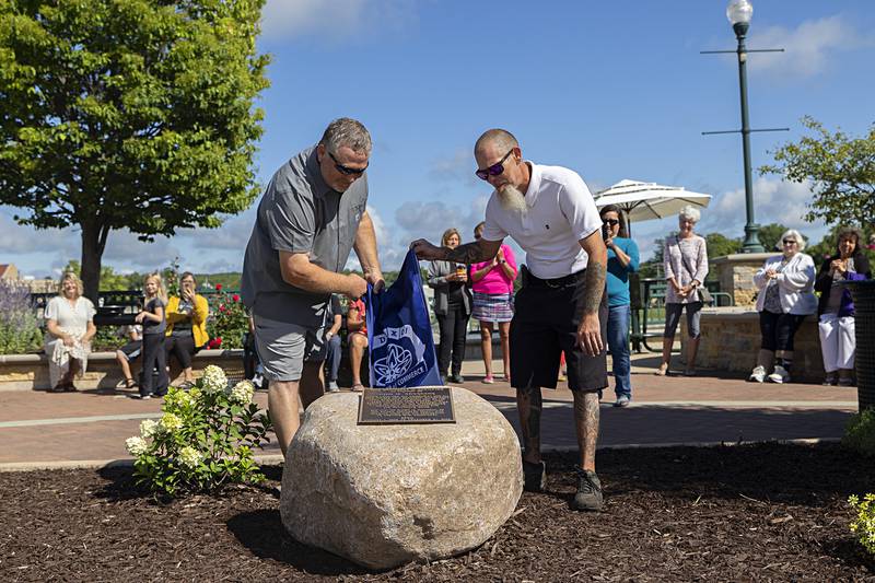 Kevin Spratt (left) and Clayton Beach unveil a plaque Friday, Aug. 9, 2024 honoring riverfront caretaker John Groshans.