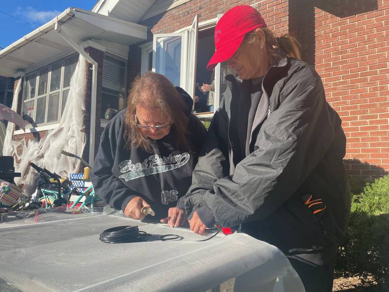 Lori Ceja (left) and Angie Wilson fix window screensduring a Labor of Love project held Saturday, Oct. 7, 2023, in the 700 block of West Main Street in Ottawa.