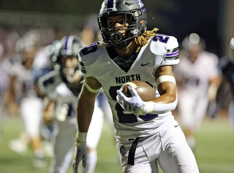 Downers Grove North’s Noah Battle (20) runs the ball against Downers Grove South during the boys varsity football game on Friday, Sept. 1, 2023.