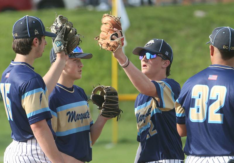 Marquette players (from left) Alec Novotney, Caden Durdan, Griffin Dobberstein and Sam Mitre wish each other good luck on the mound before playing St. Bede on Thursday, April 24, 2025 at St. Bede Academy.