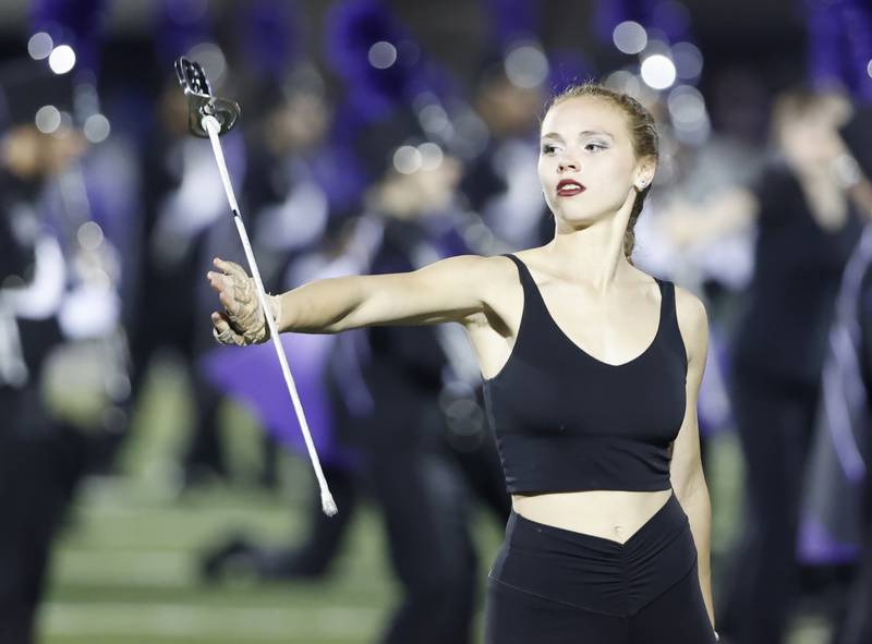 A Downers Grove North color guard twirls a sword during halftime at the varsity football game between Downers Grove North and Lyons Township on Friday, Oct. 11, 2024 in Downers Grove.