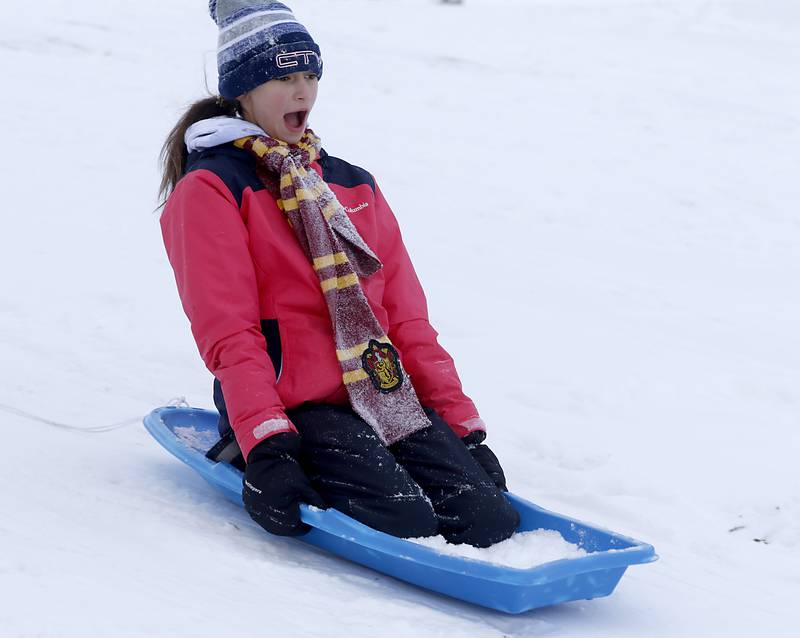 Lily Perocho, 11, of Crystal Lake, slides down the hill while sledding at Veteran Acres Park the afternoon of Monday, Jan. 24, 2022, after McHenry County received a fresh snowfall.