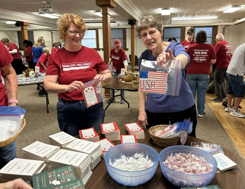 Church volunteers Rene Wehler (left) and Vinde Wells show cards created by adults and children that were part of care packages assembled for sailors on the USS Fitzgerald at the Evangelical Free Church of Mt. Morris  on Thursday, Oct. 16, 2025.