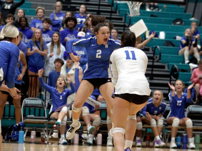 Woodstock’s Ava Sieck (2) gets the Blue Streaks hyped up late in the second set of a two-set win over rival Woodstock in varsity volleyball at Woodstock North Monday night.