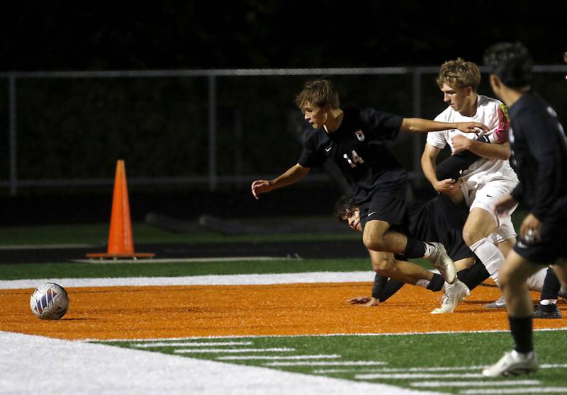 Huntley's Tyler Murray granbs the leg of McHenry's Jhosmar Mujica as McHenry's Kyren Rivard chases after the ball during a Fox Valley Conference boys soccer match on Thursday, Oct. 9, 2025, at McCracken Field in McHenry.