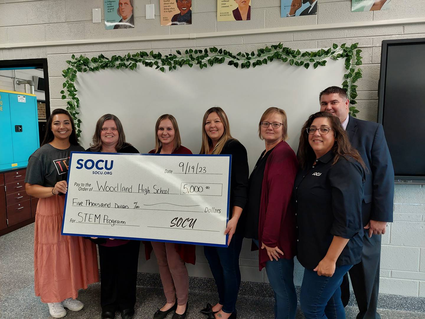 (From left) Woodland instructors Stephanie Flores, Melissa Fink and Hannah Brooks accept a $5,000 donation for STEM equipment from Dana Stillwell, Chris Cox and Angie Kusnerick, of SOCU, as Woodland Superintendent Ryan McGuckin stands behind them.