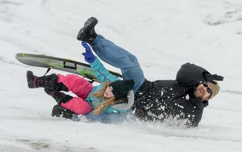 Rick Schwantes and his daughter Samantha, 9 of DeKalb crash while sledding at Hopkins Park in DeKalb on Wednesday, Dec. 30, 2020.