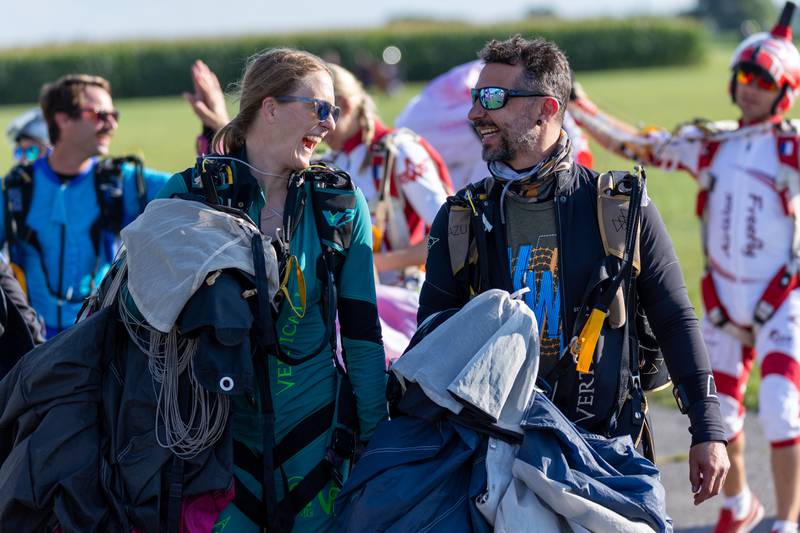 (from left) Natalie Pitts and Sergio Farrell joke after successfully landing in drop zone on Friday, Aug 22, 2025 above Skydive Chicago in Ottawa.