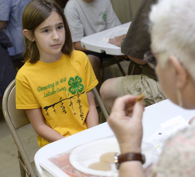 Alexandria Pedelty, of Streator, anxiously looks to the Baked Goods Judge as she samples one her peanut butter cookies Thursday, July 13, 2023, during opening day of the La Salle County 4-H Fair in Ottawa. The fair continues through Sunday.