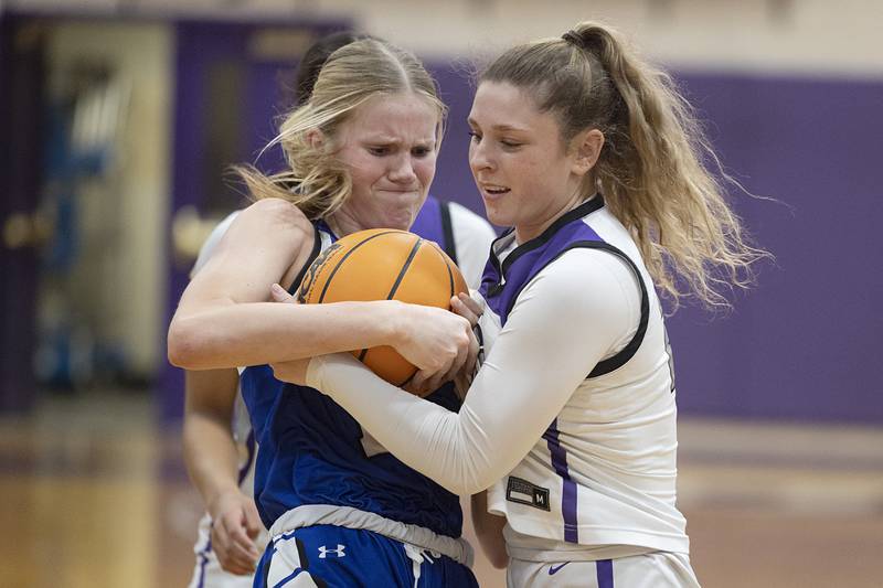 Geneva’s Emma Peterson and Dixon’s Presley Lappin fight for the ball Thursday, Feb. 19, 2026, in the Class 3A girls basketball regional title game.