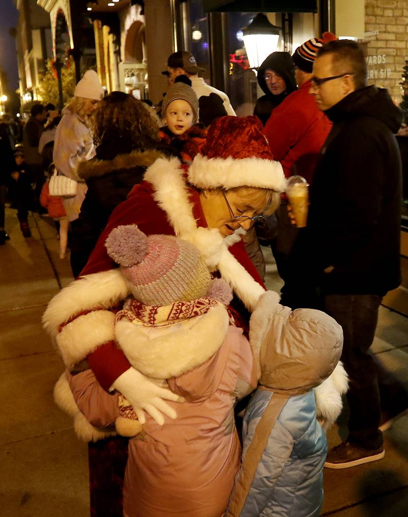 Mrs. Claus hugs children during the Lighting of the Square Friday, Nov. 25, 2022, in Woodstock. The annual event featured brass music, caroling, free doughnuts and cider, food trucks, festive selfie stations and shopping.