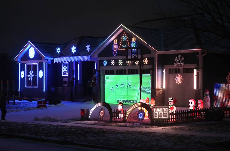 Chicago Bears highlights play on the garage door during light show put together by Tim Caravia and his family Friday, Jan. 16, 2025, at his home on Dustin Drive in Sycamore. The show will run from 5:30 to 9:00 p.m. most days until the Bears season ends.