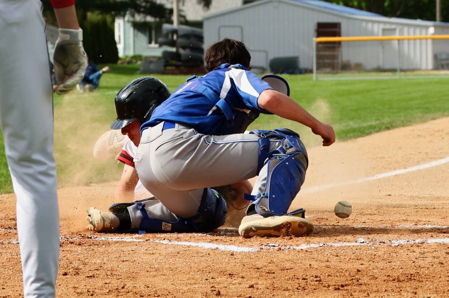 Hall's Braden Curran scores a first-inning run as the ball trickles away from Princeton catcher Ace Christiansen. The Red Devils won 10-4.