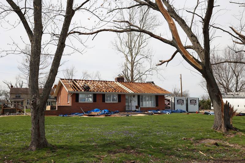 Roofers work on a home along Julie Drive in Aroma Township on April 8, 2026, nearly one month after the EF-3 tornado.