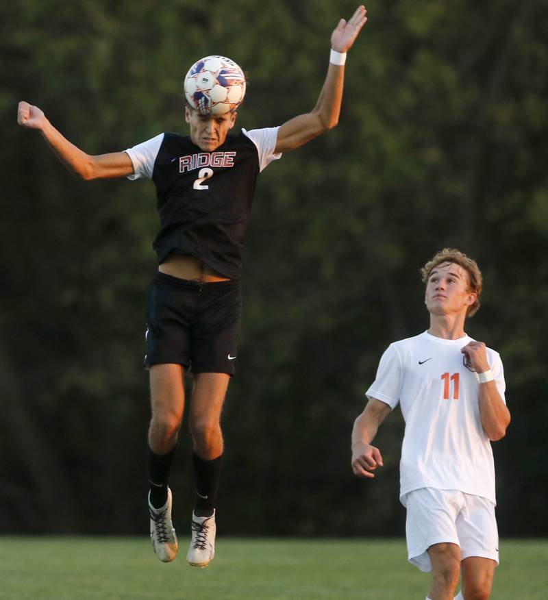 Prairie Ridge's Logan Braun heads the ball in front of Crystal Lake Central's Mason McIntyre during a Fox Valley Conference soccer match on Thursday, Oct. 10, 2024, at Prairie Ridge High School.