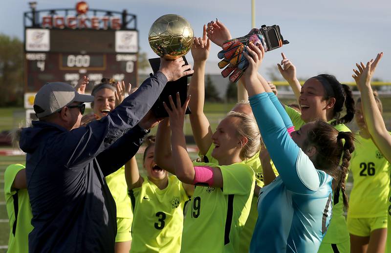 Richmond-Burton head coach Casey DeCaluwe hands the trophy to his team after they defeated Johnsburg 4-0 in the Kishwaukee River Conference Girls Soccer Tournament Championship Match on Wednesday, May 1, 2024, at Richmond-Burton High School.