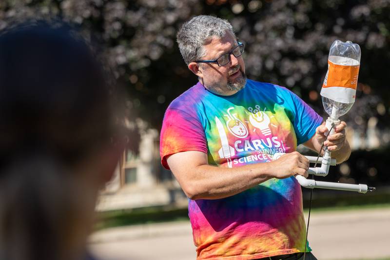 Counselor shows kids how to make two liter bottle rockets at the 23rd annual Carus Summer Science Camp on Friday, July 18, 2025 at St. Bede High School in Peru.