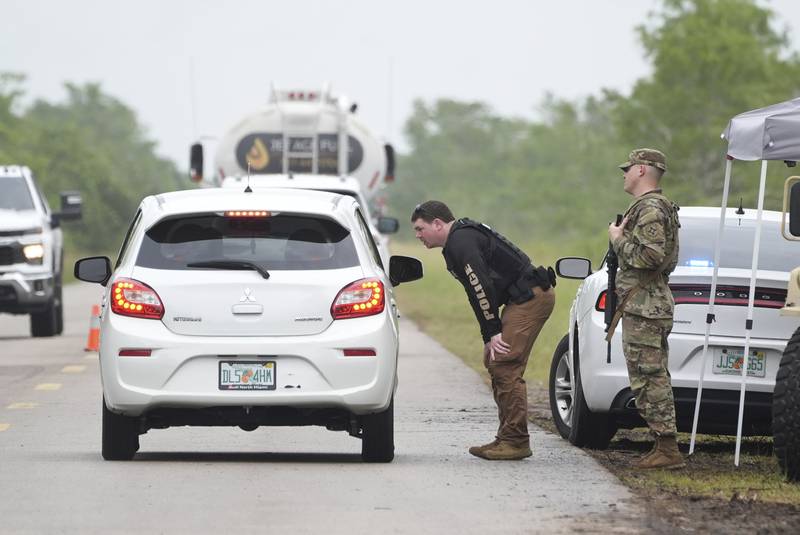 Police check cars arriving at the "Alligator Alcatraz," a new migrant detention facility at the Dade-Collier Training and Transition facility, Wednesday, July 2, 2025, in Ochopee, Fla. (AP Photo/Marta Lavandier)