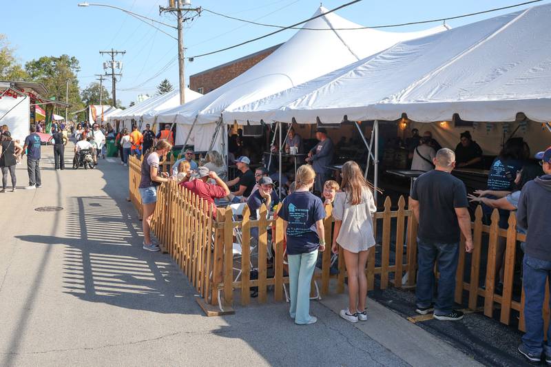 People enjoy beverages in the outdoor area of the Beer Tent at the Saint Dennis and Joseph Catholic Academy Annual Oktoberfest on Saturday, Oct. 5, 2024 in Lockport.