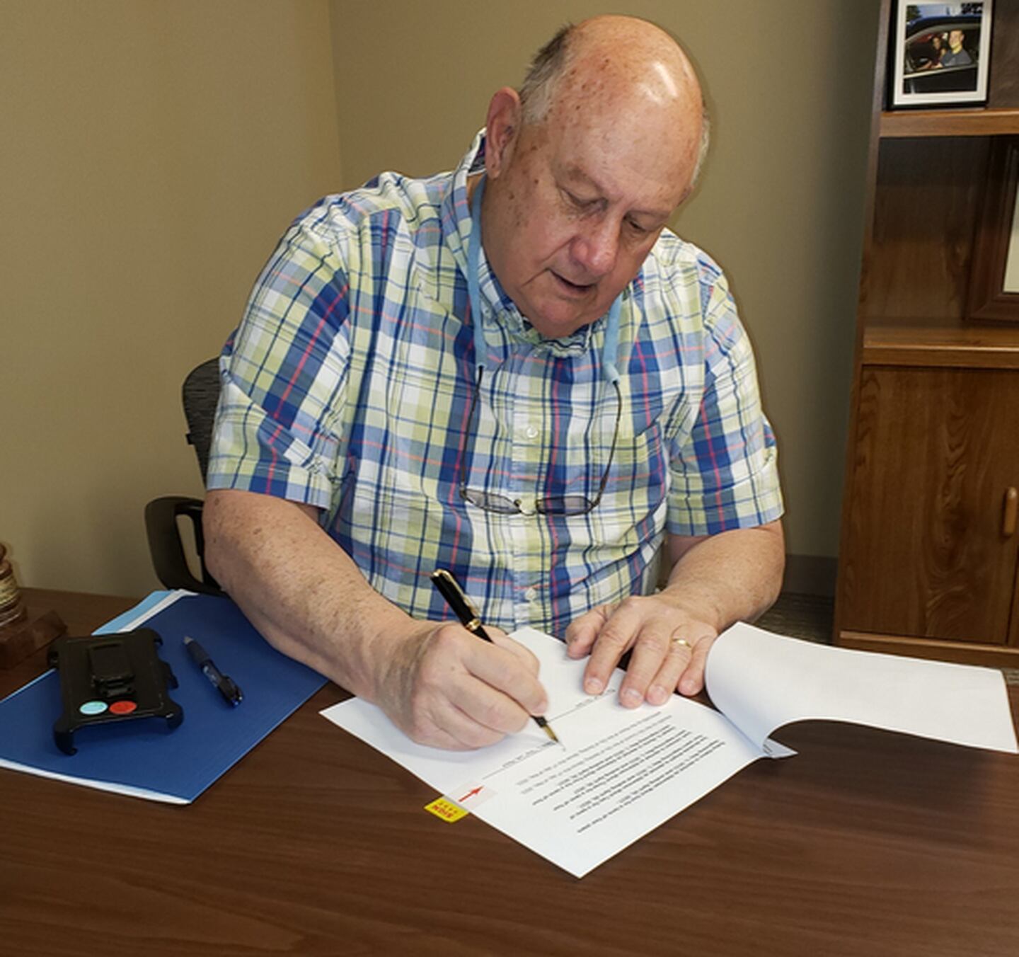Skip Lee signs his last document as Sterling mayor before yielding his gavel to new Mayor Diana Merdian, whose first day on the job was May 1, 2023.