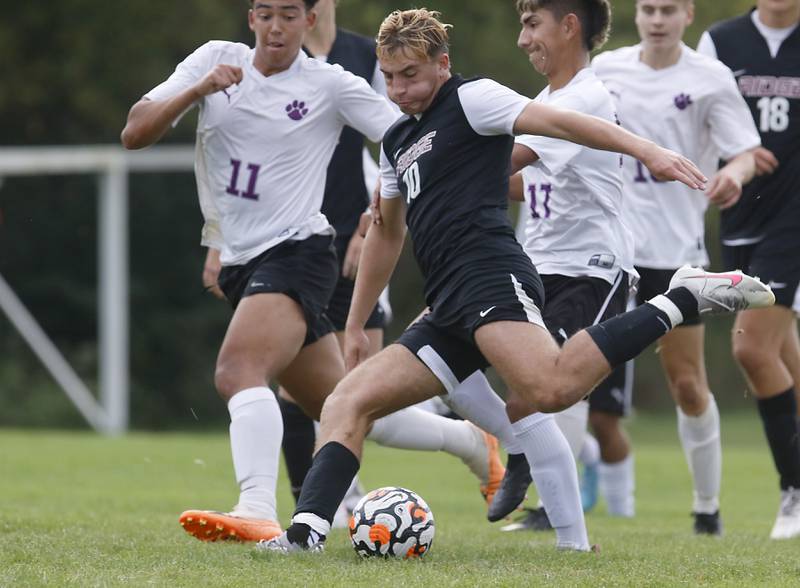 Prairie Ridge's Mason Fowler kicks a goal as he is defended by Hampshire's Evan Amagasse during a Fox Valley Conference soccer match Tuesday, Sept. 19, 2023, at Prairie Ridge High School in Crystal Lake.