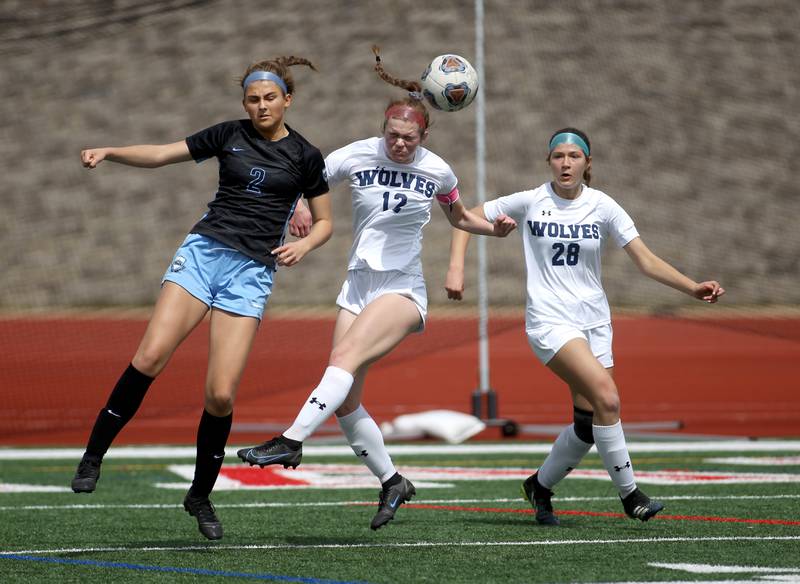 (From left) St. Charles North’s Kayla Floyd, Oswego East’s Chloe Noon and Oswego East’s Abigail Triska go after the ball during a Naperville Invitational game at Naperville Central on Saturday, April 23, 2022.