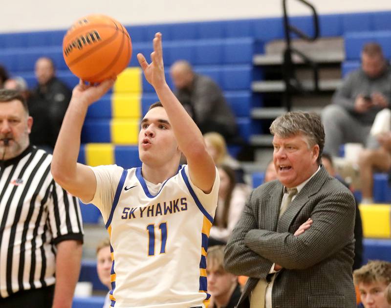 Johnsburg's Ryan Franze shoots a three pointer in front of Woodstock North Head Coach Josh Jandron during a Kishwaukee River Conference boys basketball game on Monday, Dec. 15, 2025, at Johnsburg High School.