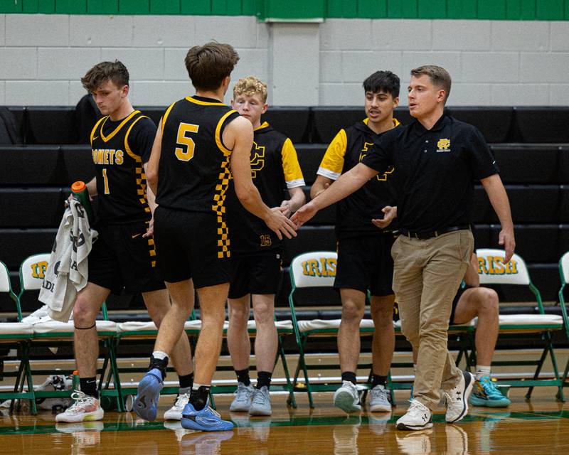 Kaiden Klein (5) of Reed-Custer high-fives coach during timeout of game against DePue in the Shipyard Showdown on Tuesday, December 23, 2025 at Seneca High School in Seneca.