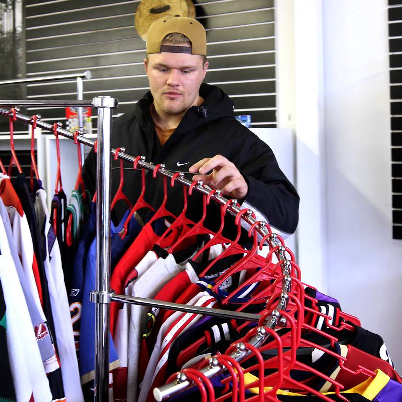 Jordan Sommers, owner of SommsVintage, a new vintage clothing store, organizes some of the jerseys he has available Wednesday, Nov. 27, 2024, ahead of Small Business Saturday at the store in DeKalb. Many locally owned shops are gearing up for Small Business Saturday which is November 30th.