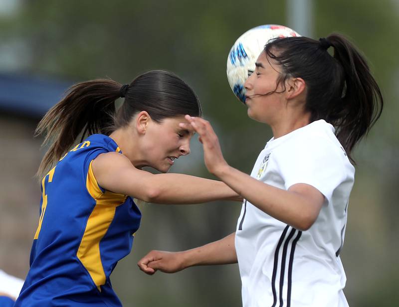 Johnsburg's Liz Smith heads the ball towards the goal as Harvard's Aimar Citlali Nava defends during a Kishwaukee River Conference soccer match on Wednesday, April 27, 2026, at Johnsburg High School.