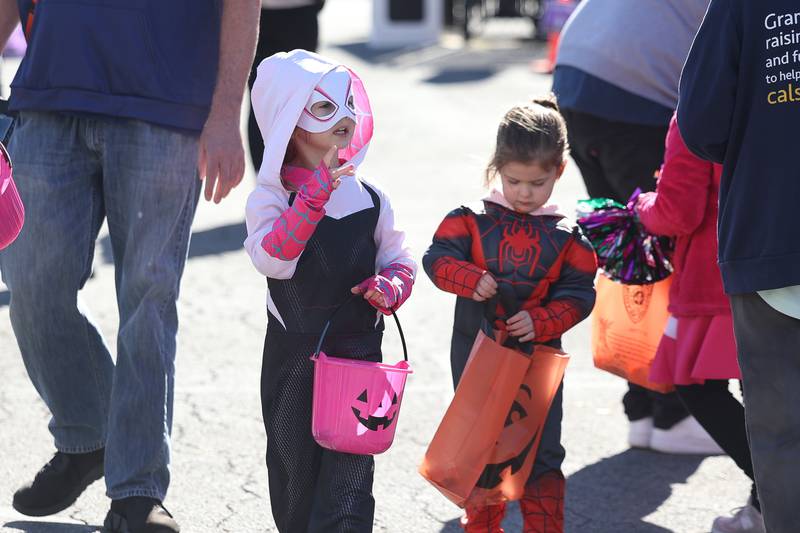 Maggie, 4, left, and her sister Riley, 2, collect candy at the Joliet Police Department Trunk-Or-Treat event on Saturday, Oct. 26, 2024 in Joliet.