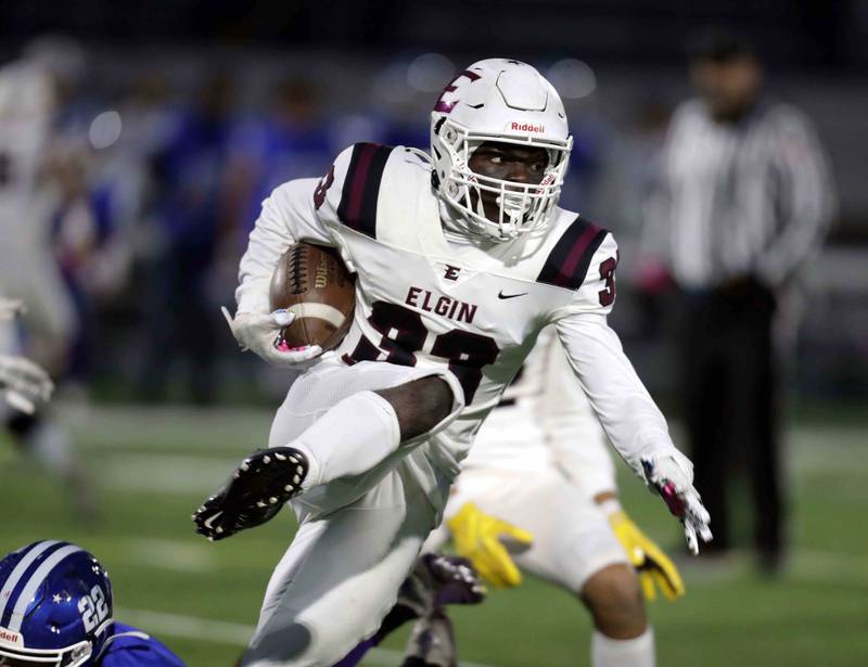 Elgin’s Matthew Lawson (33) leaps over Larkin's Kevin Malone (22) on his way upfield during the annual crosstown rival game at Memorial Field  Friday October 14, 2022 in Elgin.