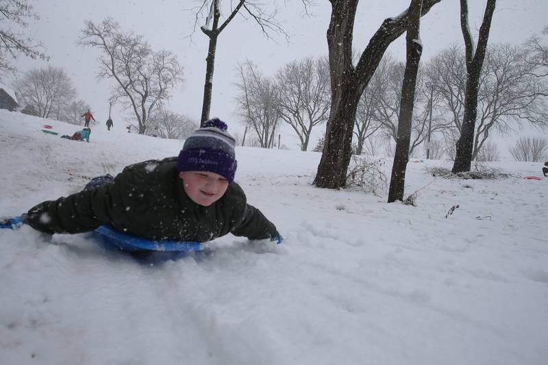 Joey Brown 11, of Peru, smiles while sledding down the steep hill on Tuesday, Jan. 9, 2024 at McKinley Park in Peru.