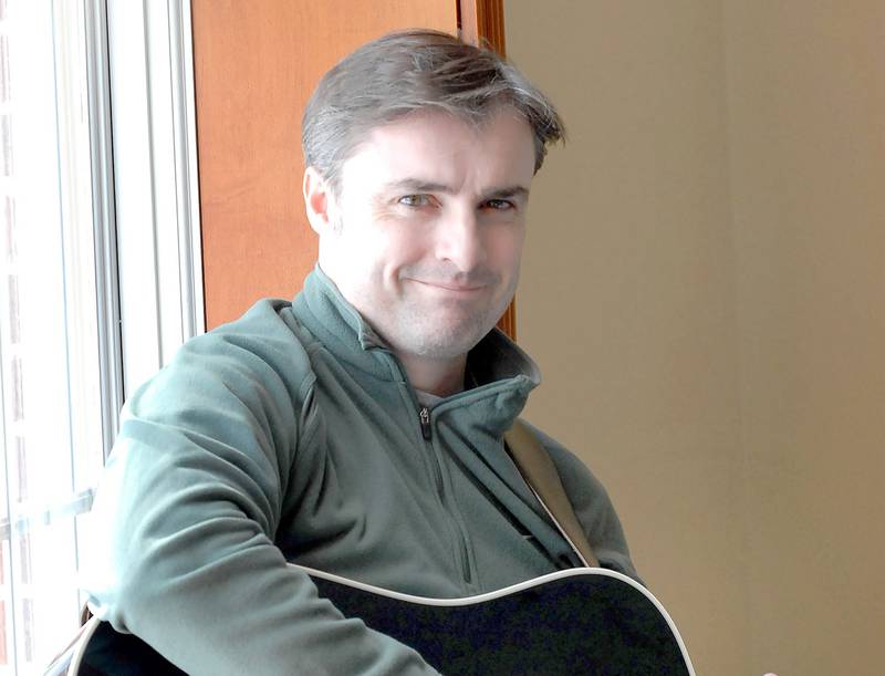 snapshots.mysuburbanlife.com/952511
Staff photo by Mark Busch
Irish-born tenor Gavin Coyle with his guitar at St. Petronille in Glen Ellyn where he teaches music at the school.