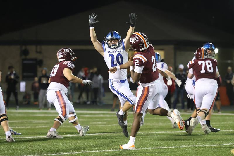 St. Charles North's Brody Teafoe puts pressure on Brother Rice's C.J Gray  in the third round of the playoffs on Saturday, Nov. 15, 2025 in Chicago.