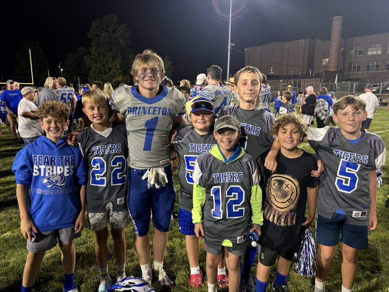 Princeton junior running back Casey Etheridge (1) scores touchdowns on Friday nights and helped coach the sixth-grade on the weekends and at practice. He's joined after one home games by several of his sixth-grade players. Pictured are (from left to right) Eli Cochran, Brecken Waca (22), Casey, Tucker Cain, Easton Wolf (12), Liam Jones, Jordan Meusel and Garrett Dever (5).
