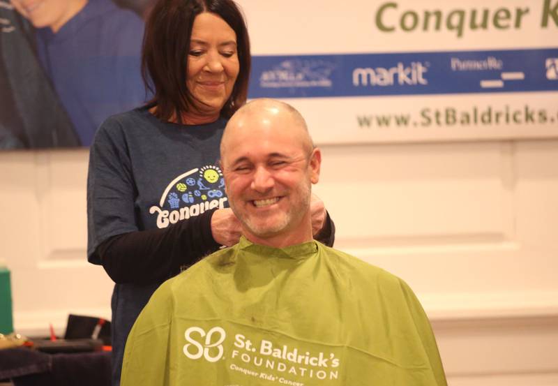 Troy Edwards, owner of Troys Place in Arlington, has his head shaved by beautician Jennifer Stoneking, owner of Utica Hair Company, during the 18th annual Illinois Valley Emergency Services St. Baldrick's event on Sunday, March 23, 2025 at Senicas Oak Ridge in La Salle.