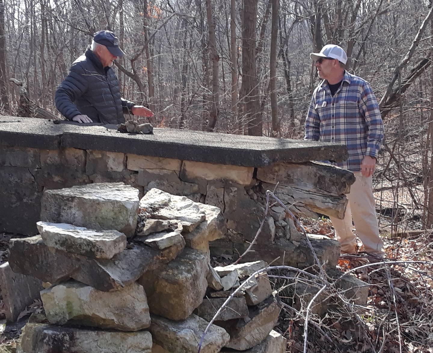 (From left) Chuck Sanders, president of the Wallace-Dickey Cemetery Preservation Association, and Keith Stehl, Ottawa Masonry, look at the current condition of the wall surrounding the Wallace-Dickey Cemetery, a land-locked private family cemetery, on the North Bluff in Ottawa.