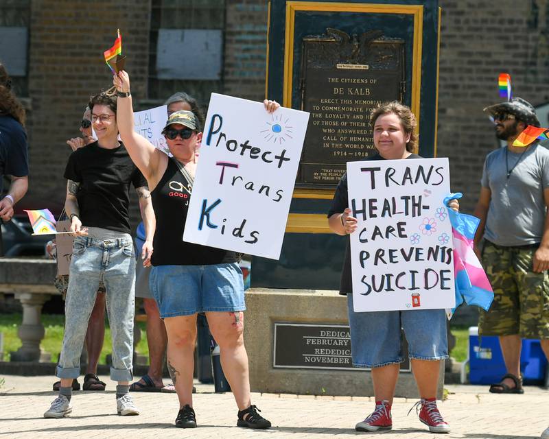 Cassandra Wyruchowski (foreground, from left) and her son Riley Wyruchowski of Cortland hold signs in support of transgender rights during a Trans Resilience Rally held on Sunday, June 22, 2025, in downtown DeKalb. Organizers said the rally was to show public support for people they believe are unjustly and harmfully targeted under President Donald Trump's policies.