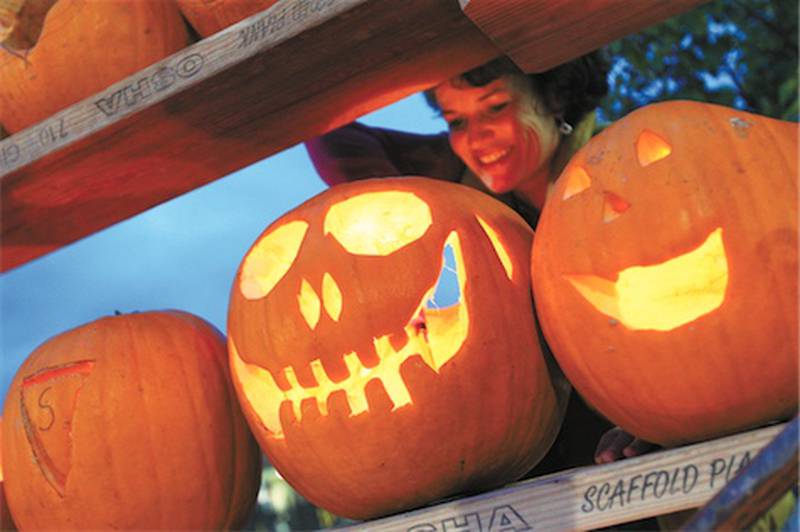 Tracy Flavin of Highwood lights jack-o-lanterns during the Great Highwood Pumpkin Festival on Oct. 23.