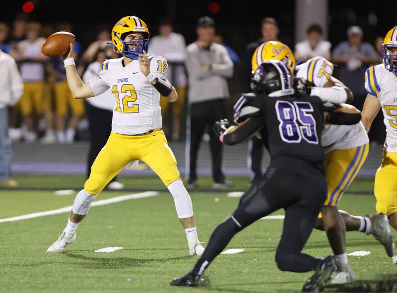 Lyons' Dom Pisciotti (12) drops back to pass during the varsity football game between Downers Grove North and Lyons Township on Friday, Oct. 11, 2024 in Downers Grove.