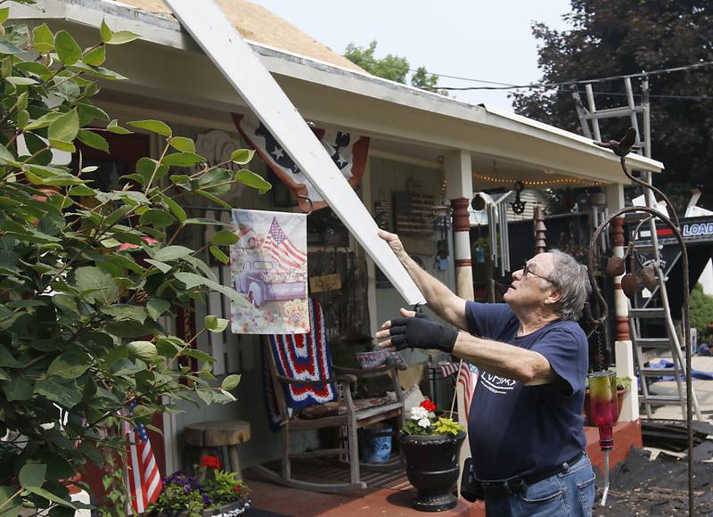 U.S. Army veteran George Kanaly collects a piece oh hose siding from a worker from Apex General Contracting as they install a  new roof Thursday, June 15, 2023, at Kanaly’s home in Marengo. The Vietnam veteran’s new roof is being provided by the Owens Corning Roof Deployment Project, Habitat for Humanity of McHenry County and Apex General Contracting.