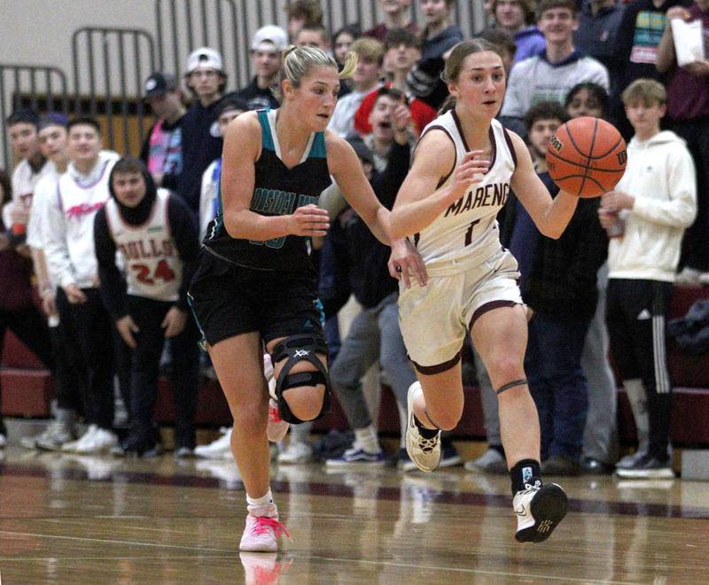 Marengo’s Emily Kirchhoff moves the ball against Woodstock North’s Addison Rishling in varsity girls basketball at Marengo Tuesday evening.