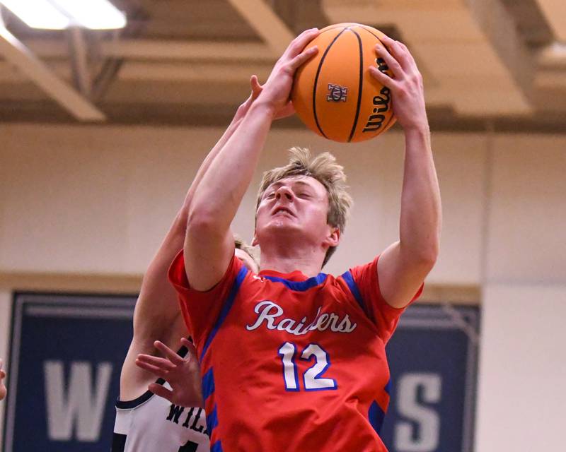 Glenbard South's Mitchell Erickson (12) makes a basket while being defended by West Chicago's Peter Bovey (10) during the game on Friday Jan. 3, 2025, held at West Chicago High School.
