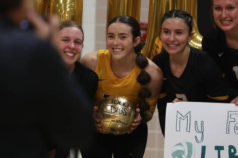 Joliet West’s Olivia Baxter takes a photo with the team as she is honored for her 1,000 career dig before the match against Minooka on Tuesday, Sept. 26, 2023 in Joliet.