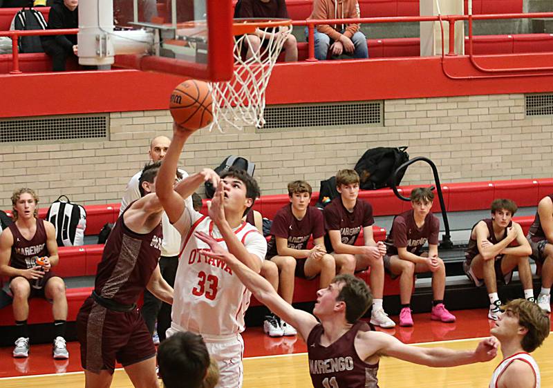 Ottawa’s Cooper Knoll (33) runs in the lane to score a basket as Marengo’s Patrick Signore (11) defends during the Dean Riley Shootin’ The Rock Tournament on Monday, Nov. 21, 2022 at Kingman Gymnasium.