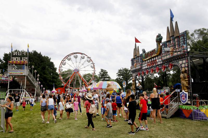 People walk along checking out the rides Friday, July 1, 2022, during Lakeside Festival at the Dole and Lakeside Arts Park, 401 Country Club Road in Crystal Lake. The festival continues noon to 11 p.m. July 2 and noon to 10 p.m. July 3. The festival features bands on two outdoor stages, food and drinks, a baggo tournament, and carnival rides and games. Among the activities for kids are face painting, a balloon twister, a stilt walker, team mascots and a magician.