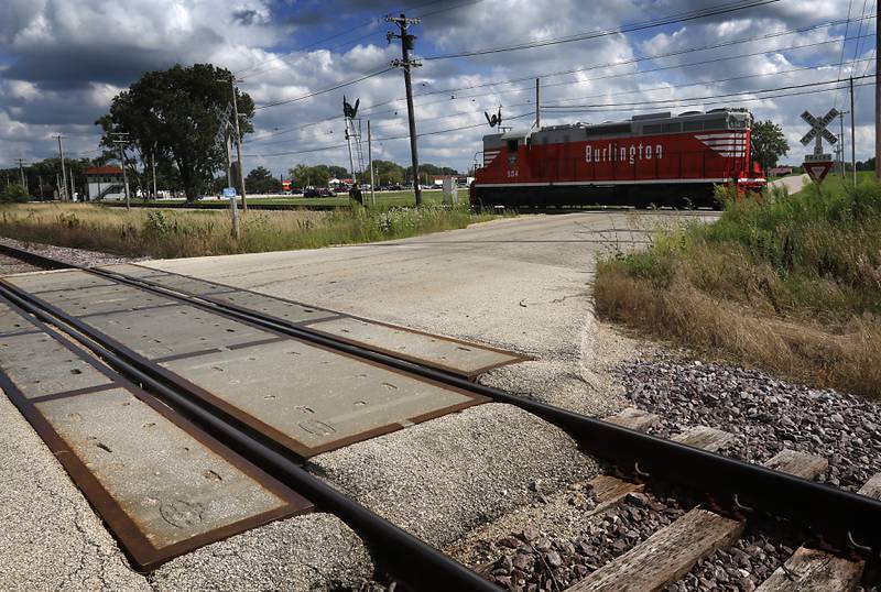 A diesel locomotive from the Illinois Railway Museum  crosses Olsen Road Friday, Aug. 11, 2023, on the museum's train tracks that are just south of the railroad tracks the proposed Metra route will use to connect Rockford and Huntley with Chicago.