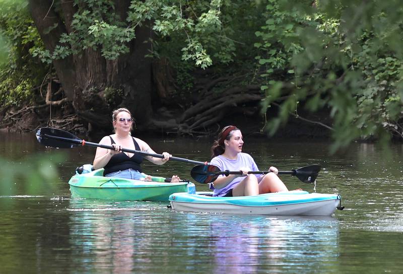 Kosova Gashi, (left) from Cortland, and Tessa Hadley, from DeKalb, paddle downstream in the Kishwaukee River Sunday, July 31, 2022, near David Carrol Memorial Citizens Park in Genoa.